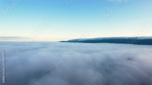 Flying through carpet of fog towards the mountains  photo