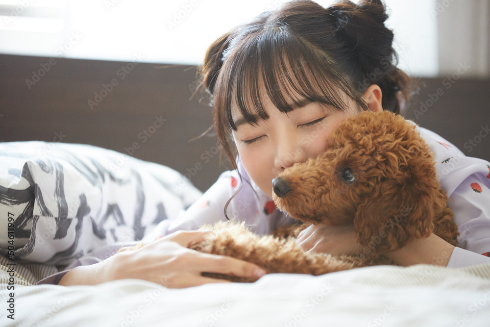 ペットと過ごすパジャマ姿の若い女性 ペットと過ごすパジャマ姿の若い女性
