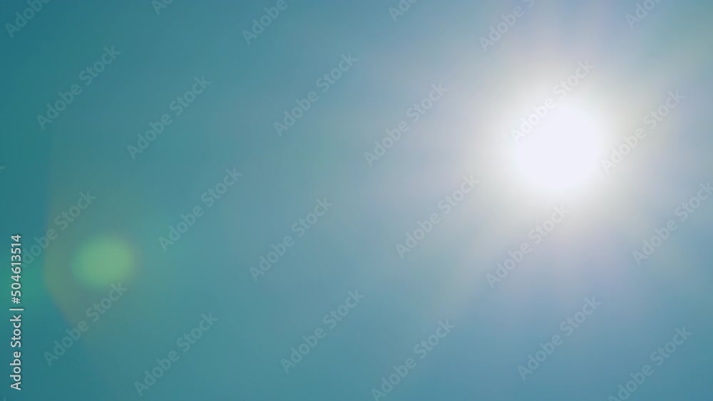 Bright shining sun in a blue sky no clouds. Tropical summer sunlight. Real time.