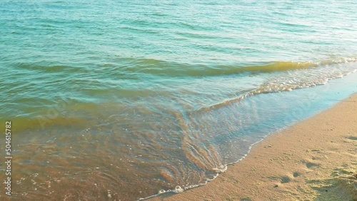 Waves on the sandy shore of the Black Sea. Sunny weather.