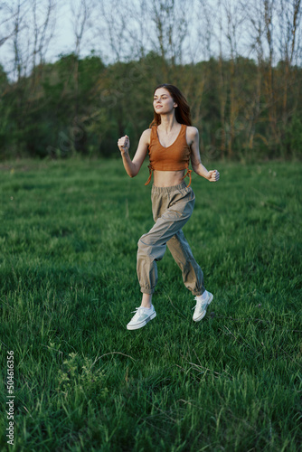 An athletic woman runs and trains her body before the summer season in the park