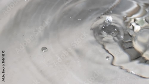 Water is dripping from a faucet into the sink. Water splashes in slow motion.