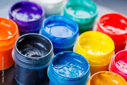 Foto full-frame close-up background of opened small gouache paint jars on black