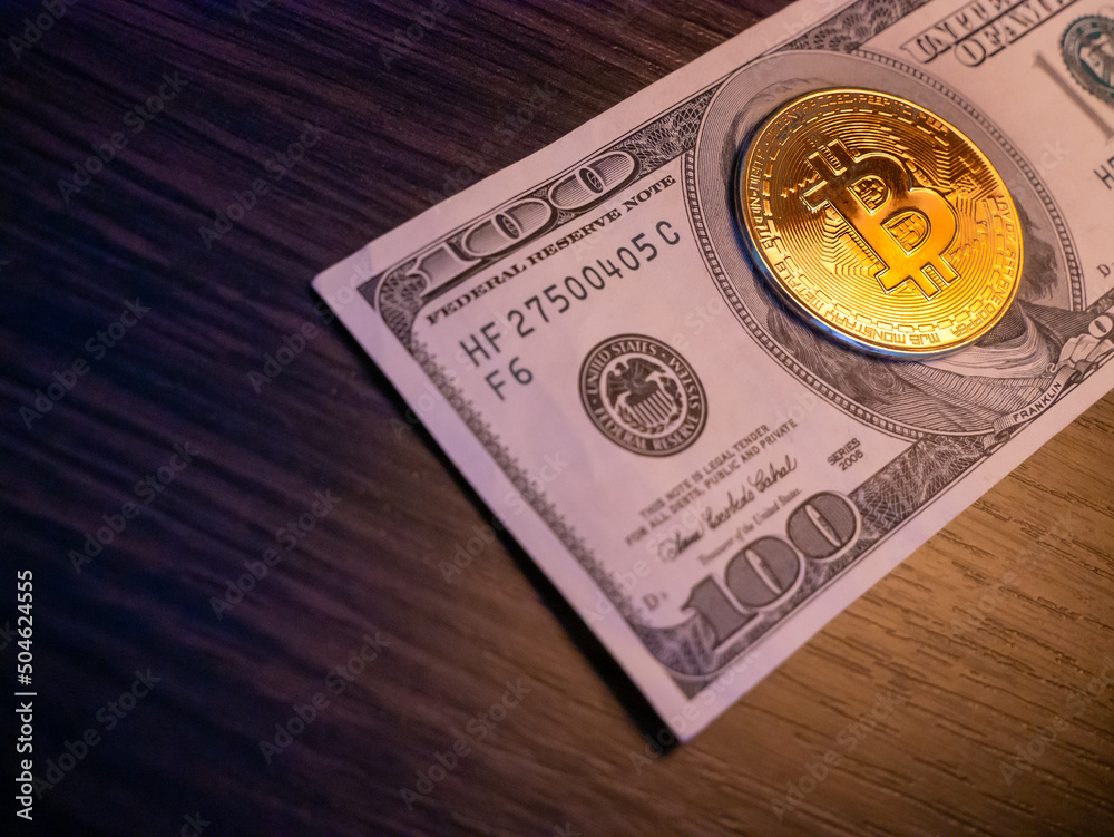 A symbolic coins of bitcoin on banknotes of dollars. Exchange bitcoin cash for a dollar. A symbolic coins of bitcoin on banknotes of dollars. Exchange bitcoin cash for a dollar.