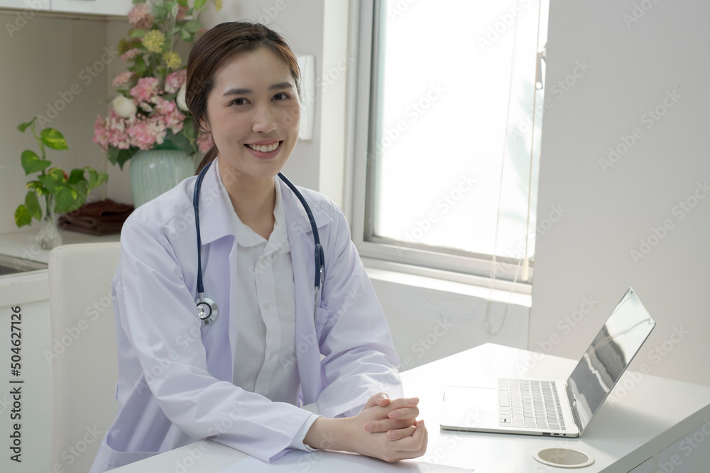 Young Female Doctor in white coat sitting at her workplace working. Doctor sitting at desk and writing a prescription for her patient. Smiling female doctor working in doctor’s office. Young Female Doctor in white coat sitting at her workplace working. Doctor sitting at desk and writing a prescription for her patient. Smiling female doctor working in doctor’s office.