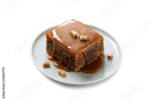 Easy Sticky Toffee Pudding is a deliciously gooey sponge cake drenched in warm toffee sauce that’s a favorite among the English. isolated on white background   photo