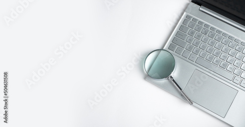 Φωτογραφία Technology banner with laptop keyboard and magnifying lens with copy space for text