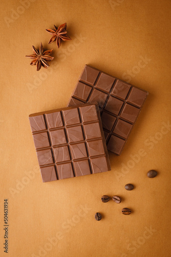 chocolate on a brown background with coffee beans and star anise. Creative chocolate photography. Sweet foodood