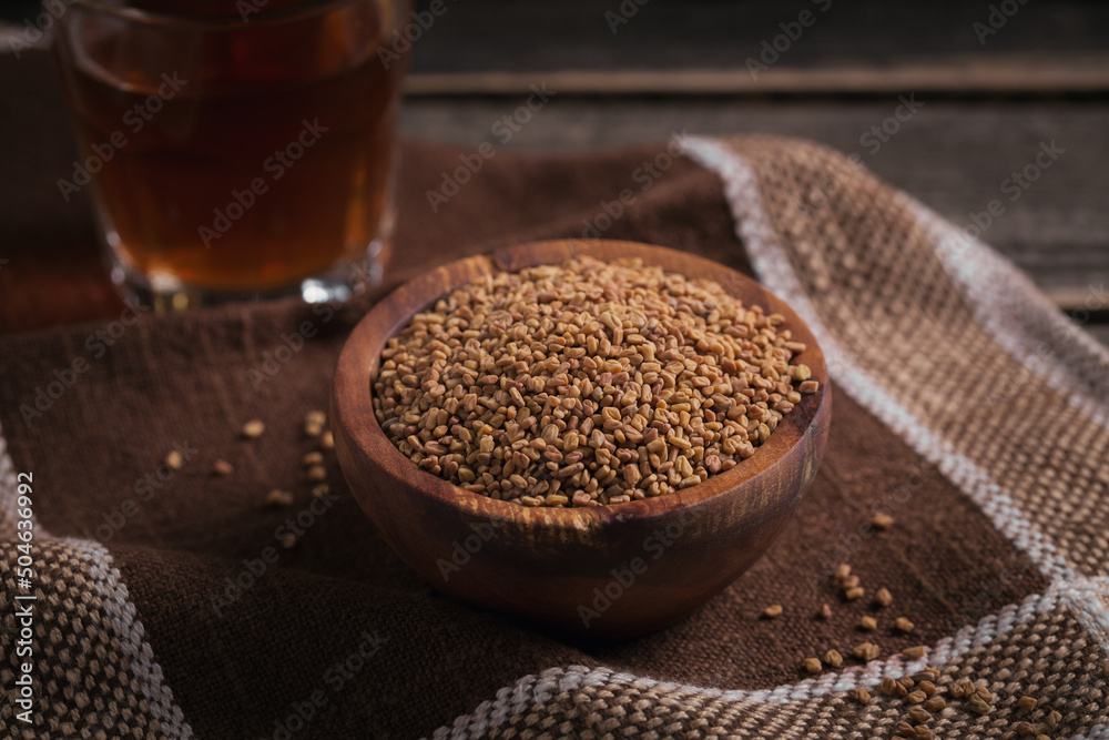 Bowl of fenugreek seeds and Egyptian fenugreek yellow tea or Methi Dana drink - obrazy, fototapety, plakaty 