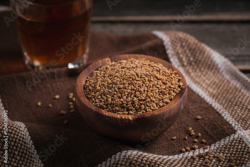 Bowl of fenugreek seeds and Egyptian fenugreek yellow tea or Methi Dana drink photo