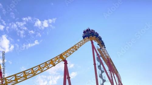 People passengers in trolley ride at high speed on extreme roller coaster. Popular attraction themed amusement park