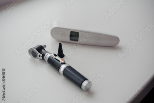 Non-contact thermometer on a white background for measuring body temperature. Otoscope on a white background, a device for examining the auricle and middle ear