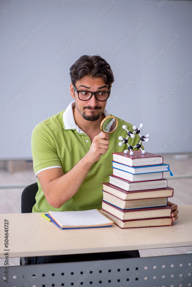 Young male student chemist preparing for exams in the classroom Young male student chemist preparing for exams in the classroom