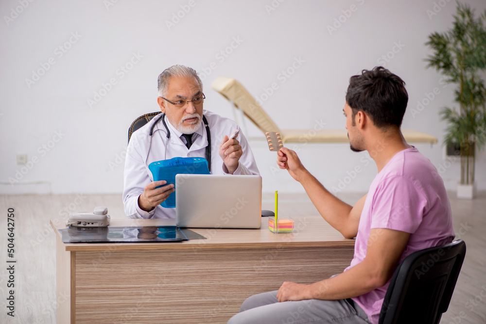 Obraz premium Young male patient visiting old male doctor