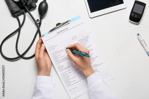 Female doctor writing in la...