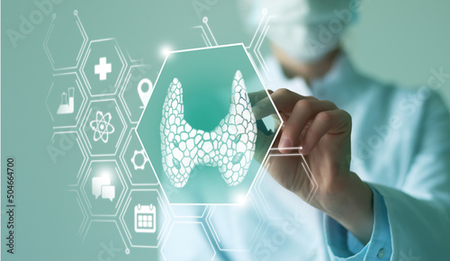 Unrecognizable female doctor holding shield and graphic virtual visualization of Thyroid Gland organ in hands. photo