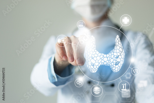 Unrecognizable female doctor holding shield and graphic virtual visualization of Thyroid Gland organ in hands.