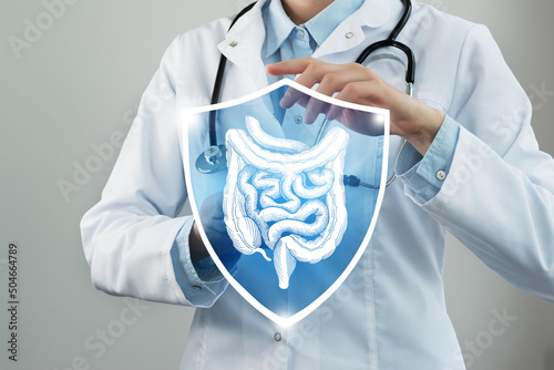 Фотография Unrecognizable female doctor holding shield and graphic virtual visualization of Intestine organ in hands