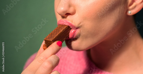 Close up of beautiful girl eating chocolate cookies