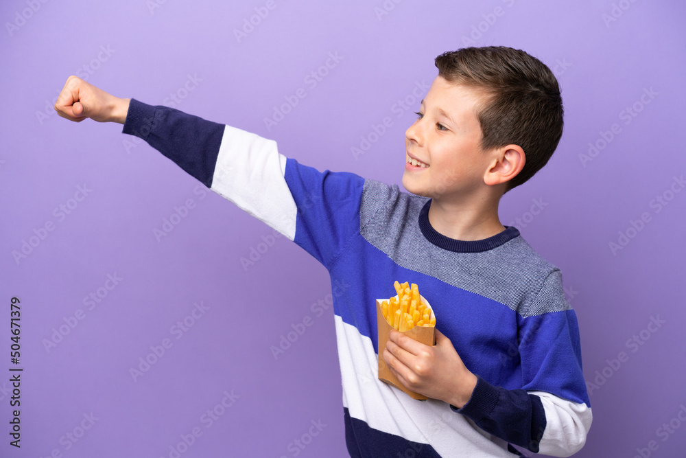 Little boy holding fried chips isolated on purple background giving a thumbs up gesture Little boy holding fried chips isolated on purple background giving a thumbs up gesture