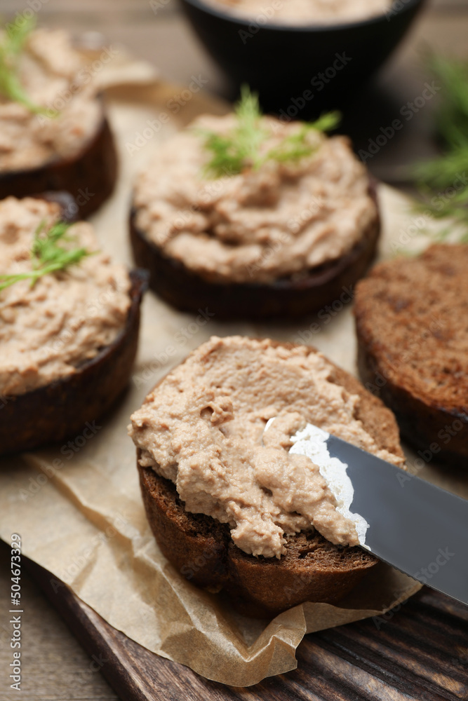 Slices of bread with delicious pate on wooden table, closeup