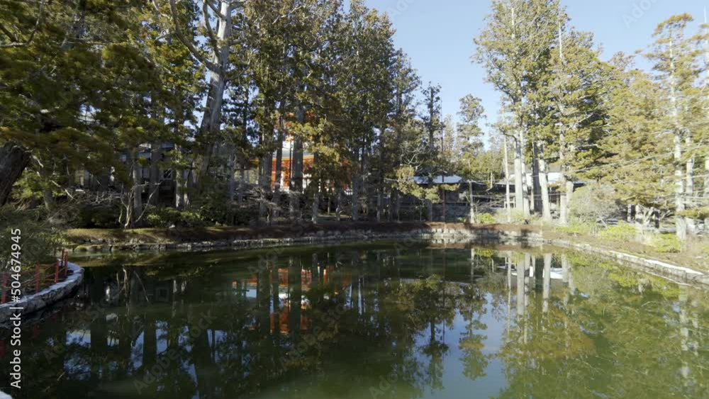 Cinematic gimbal shot of historic bridge over pond at Buddhist temple in Mount Koya in Wakayama prefecture, Japan Cinematic gimbal shot of historic bridge over pond at Buddhist temple in Mount Koya in Wakayama prefecture, Japan