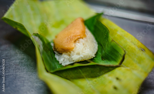 Custard egg sticky rice dessert wrapped in banana leaves, sold as a dessert in Bangkapi Market, Bangkok, Thailand.