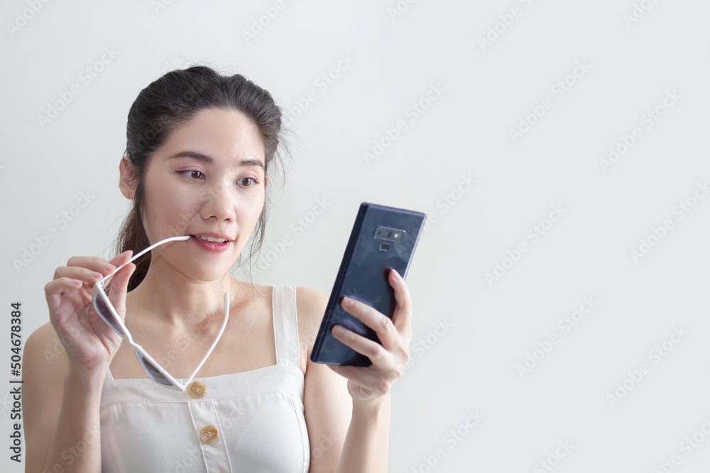 Asian beautiful woman raise arm up and holding smartphone and smile with happiness to success shopping online or win lottery Asian beautiful woman raise arm up and holding smartphone and smile with happiness to success shopping online or win lottery