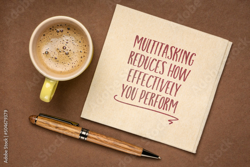 multitasking reduces how effectively your perform - warning and reminder note on a napkin with coffee, productivity and personal development concept