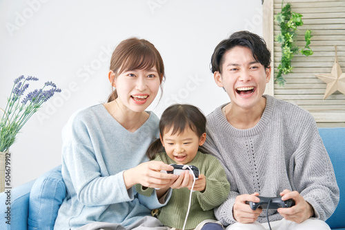 両親と娘 テレビゲームで遊ぶ リビング