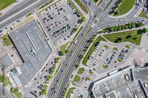urban life. shopping center with parking lots and car traffic on city streets. aerial top view with drone.