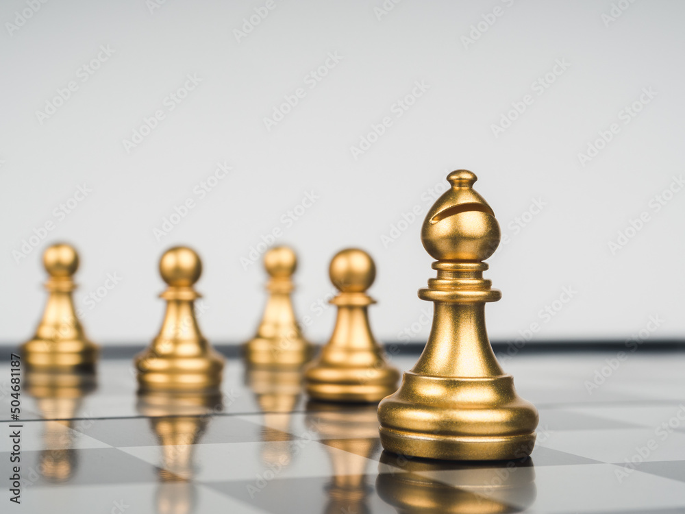 The golden bishop chess piece in front of gold pawns on chess board, white background. Bishop represents the church, important and powerful entity throughout history, religious representative concept. The golden bishop chess piece in front of gold pawns on chess board, white background. Bishop represents the church, important and powerful entity throughout history, religious representative concept.