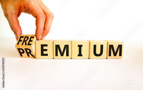 Premium or freemium symbol. Businessman turns wooden cubes and changes the concept word Premium to Freemium. Beautiful white table white background. Business premium or freemium concept. Copy space. photo