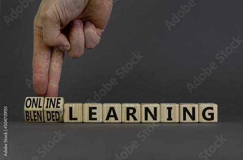 Blended or online learning symbol. Businessman turns cubes changes words blended learning to online learning. Grey background. Business, education and blended or online learning concept. Copy space.