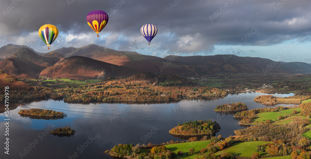 Digital composite image of hot air balloons over Beautiful landscape Autumn image of view from Walla Crag in Lake District, over Derwentwater looking towards Catbells and distant mountains