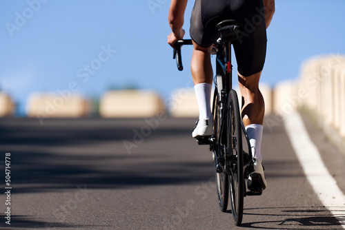 Fototapeta Naklejka Na Ścianę i Meble -  Male cyclist riding racing bicycle, man cycling on countryside summer road. Training for triathlon or cycling competition