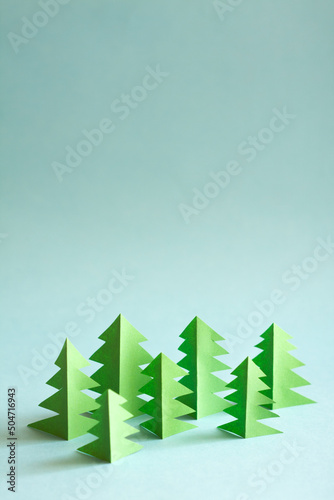 Paper forest with free copy paste space for text. Green paper trees on blue background.