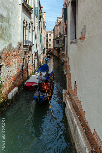 Gondoliers on the canals of Venice carry tourists.