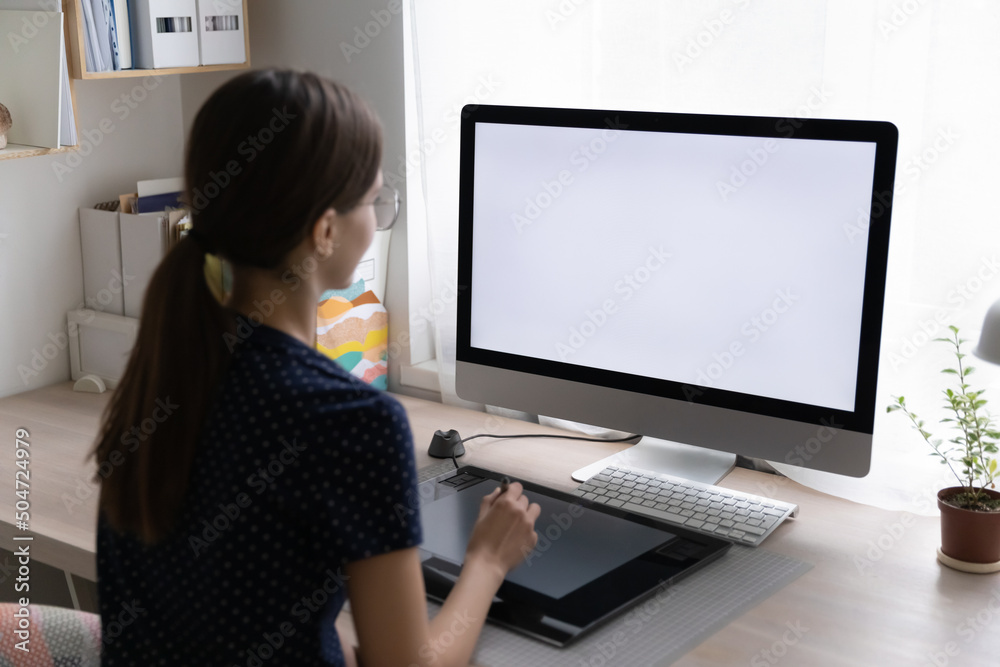 Freelance designer drawing sketch on graphic tablet at desktop big monitor, blank display. Professional girl working on design project at home. Using creative job digital equipment. Freelance designer drawing sketch on graphic tablet at desktop big monitor, blank display. Professional girl working on design project at home. Using creative job digital equipment.