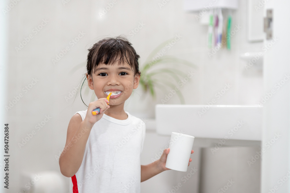 Little cute baby girl cleaning her teeth with a toothbrush in the bathroom Little cute baby girl cleaning her teeth with a toothbrush in the bathroom