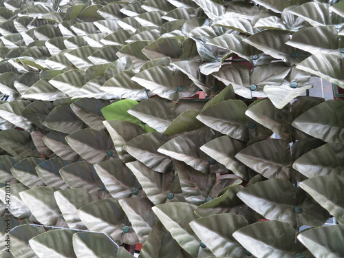 Photography gate covered with pale green plastic leaves