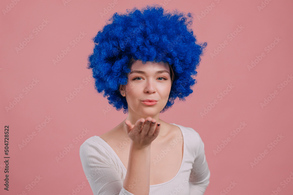 Close-up Portrait of Young Smiling Woman In blue Wig. Millennial woman blows kiss. Close-up Portrait of Young Smiling Woman In blue Wig. Millennial woman blows kiss.