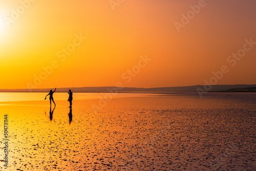 Fototapeta Naklejka Na Ścianę i Meble -  silhouette of man posing on salt lake at sunset