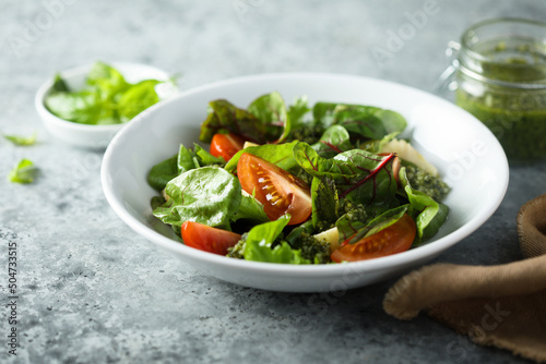 Healthy green salad with tomatoes and pesto