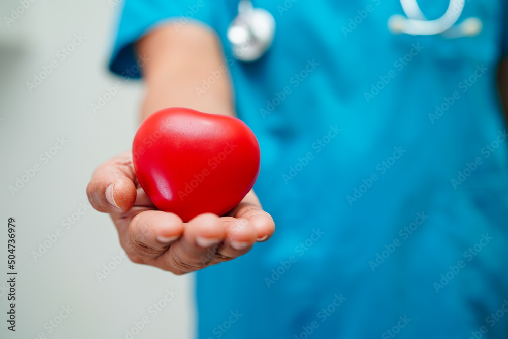 Asian woman doctor holding red heart for health in hospital. Asian woman doctor holding red heart for health in hospital.