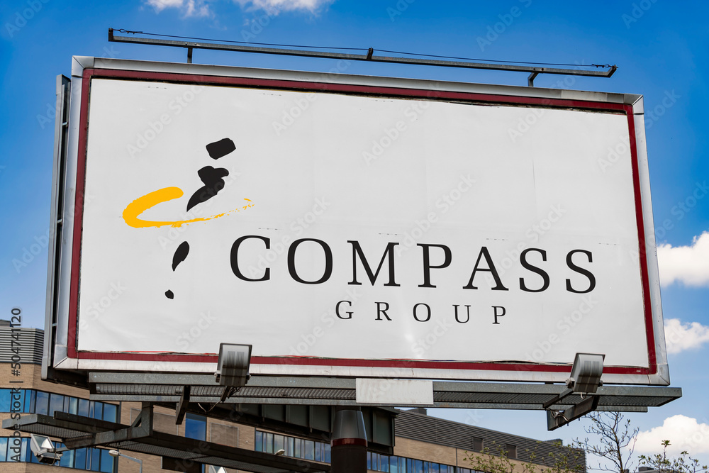 Advertisement billboard displaying logo of Compass Group Stock Photo