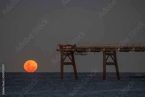 Full moon rise over Pier at Catherine Hill Bay, Newcastle, NSW, Australia