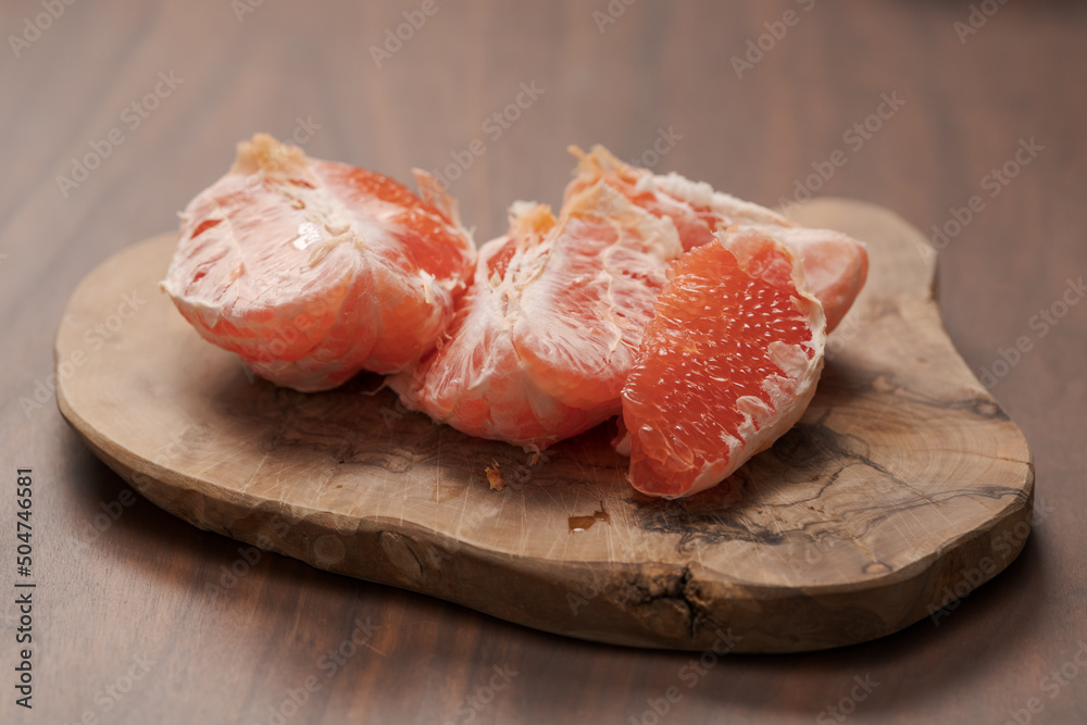 Peeled grapefruit on olive serving board
