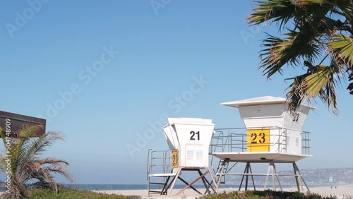 Lifeguard stand and palm tree, life guard tower for surfing on California beach. Summer pacific ocean in USA aesthetic. Iconic rescue baywatch station, coast lifesavers wachtower hut or house by sea.