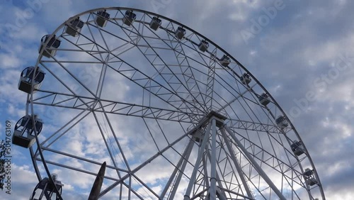 Ferris wheel on a background of blue sky and clouds. Entertainment park